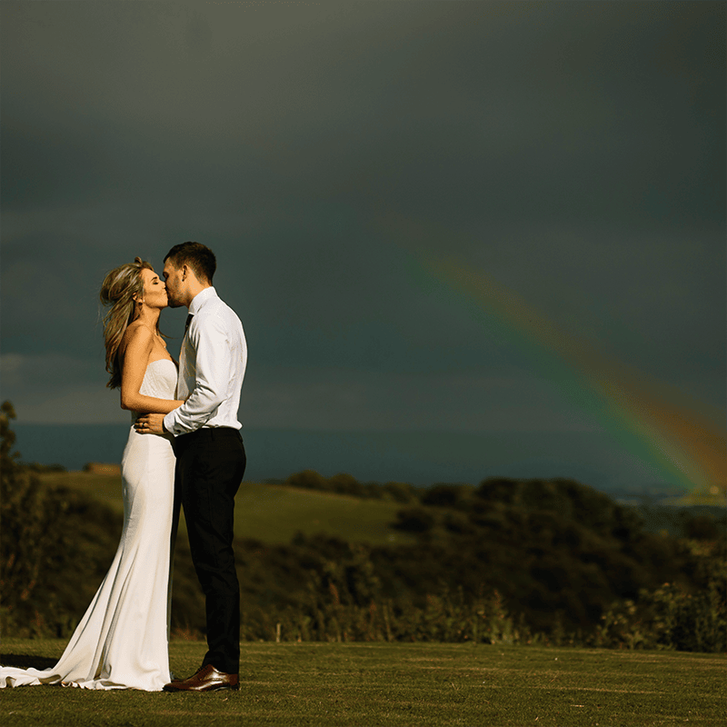 Wedding couple outside under a rainbow - Camellio Wedding Planning and Events - Essex Wedding Planner