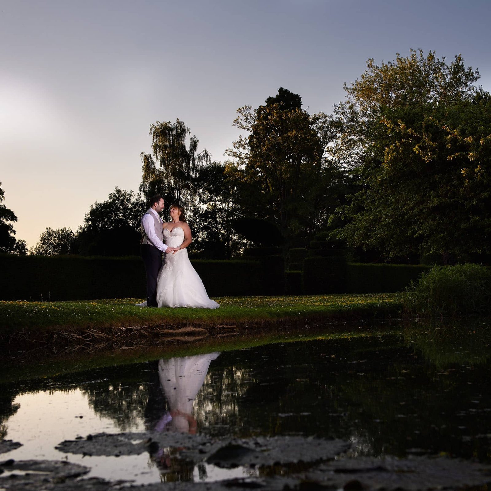 Newly wed couple reflection in water